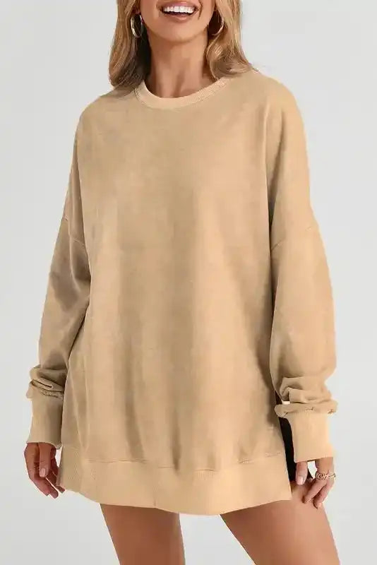 Back view of beige oversized sweatshirt styled as a dress, featuring ribbed hem and relaxed fit for a chic western winter look.