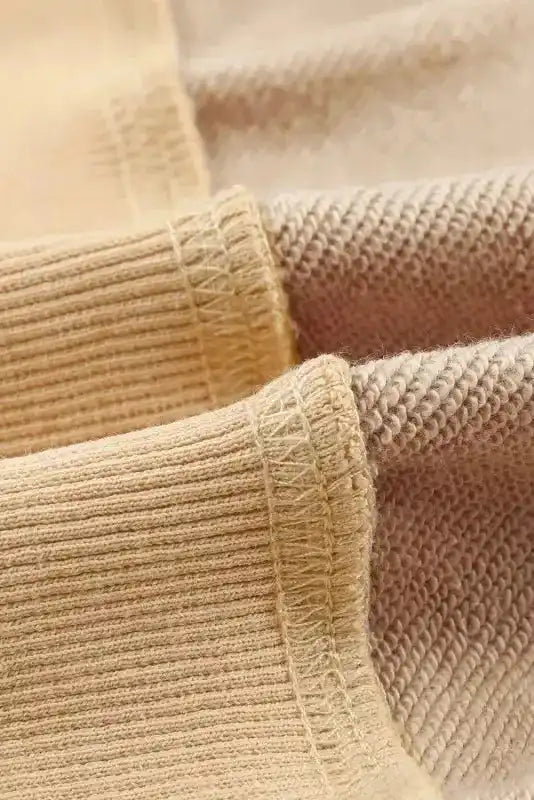 Macro shot of beige sweatshirt fabric showing soft knit texture, perfect for cozy and stylish winter layering.