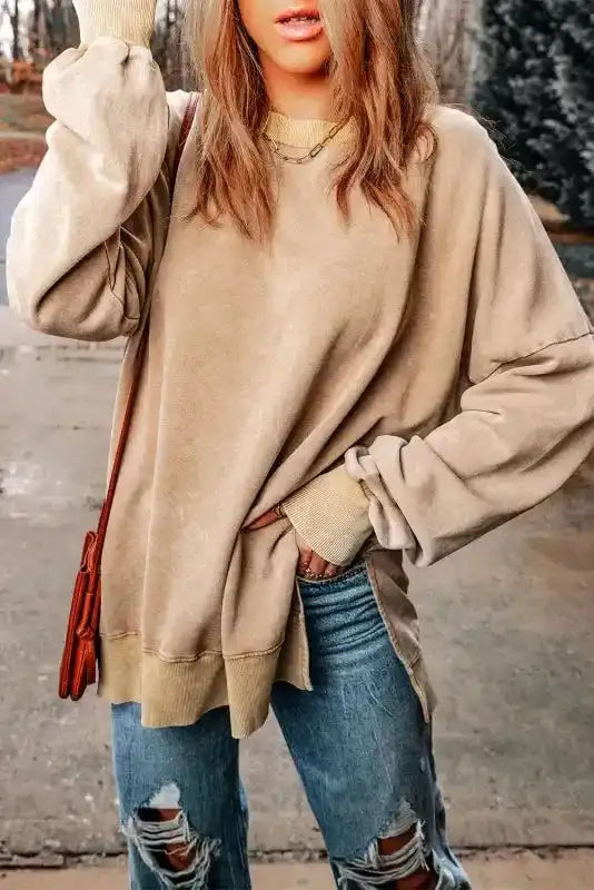 Side view of beige slit sweatshirt with long bishop sleeves and ribbed cuffs, styled for a laid-back western fashion look.