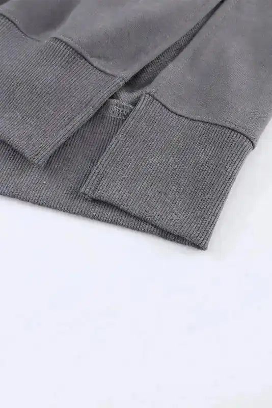 Close-up of ribbed cuffs and side slit hem on Leopard Patchwork Bishop Sleeve Sweatshirt | Unique & Trendy, showing detailed stitching.