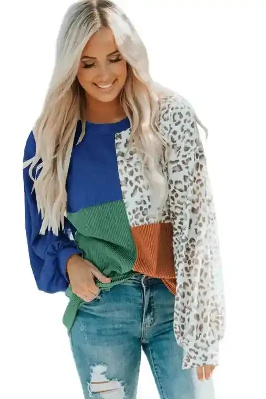 Leopard patchwork long sleeve top with ribbed color block panels in blue, green, and rust, styled with ripped jeans for a casual fall outfit.