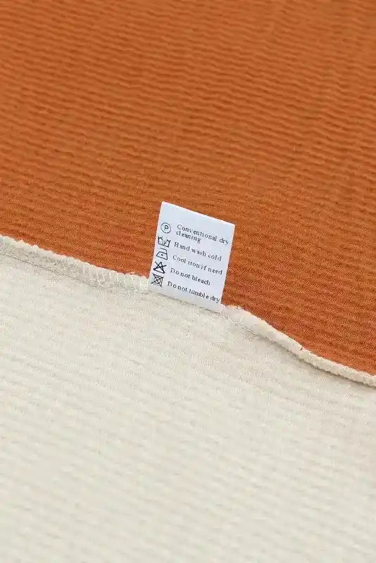 Care label on long sleeve tops leopard patchwork color block ribbed long showing washing instructions and fabric composition.