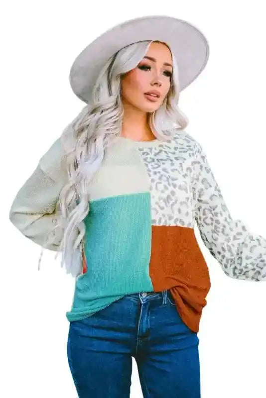 Model in hat wearing long sleeve tops leopard patchwork color block ribbed long styled with jeans for a casual fall look.