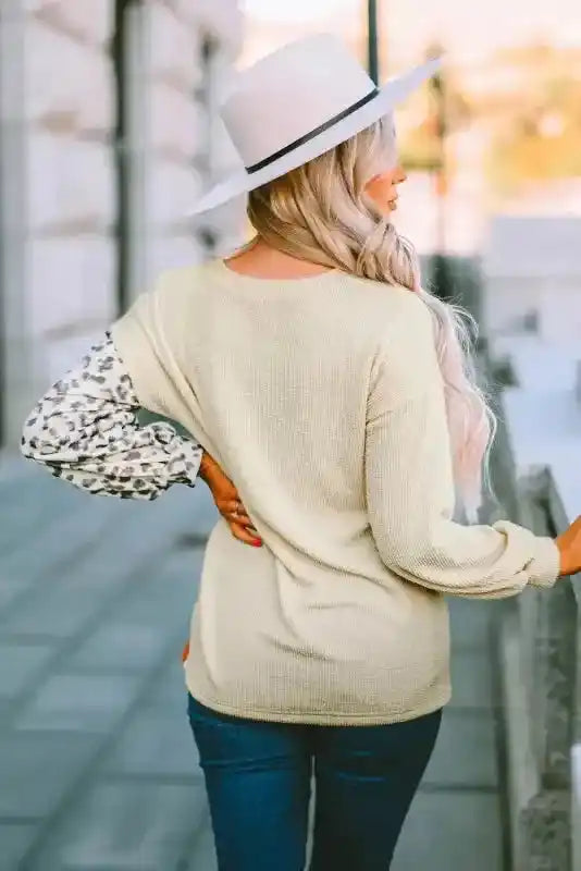 Back view of beige ribbed long sleeve top with leopard print sleeve and relaxed fit, styled for fall casual outfits.