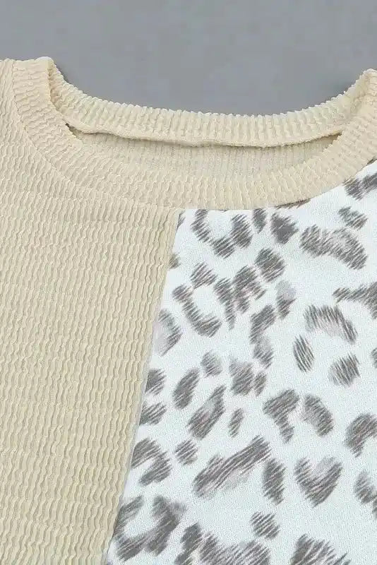 Close-up of neckline on long sleeve tops leopard patchwork color block ribbed long featuring beige ribbed knit and leopard print fabric.