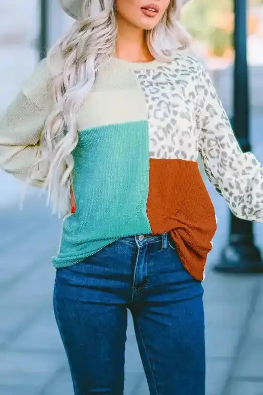 Leopard patchwork ribbed long sleeve top in beige, teal, and rust color blocks, styled with dark denim jeans for autumn.
