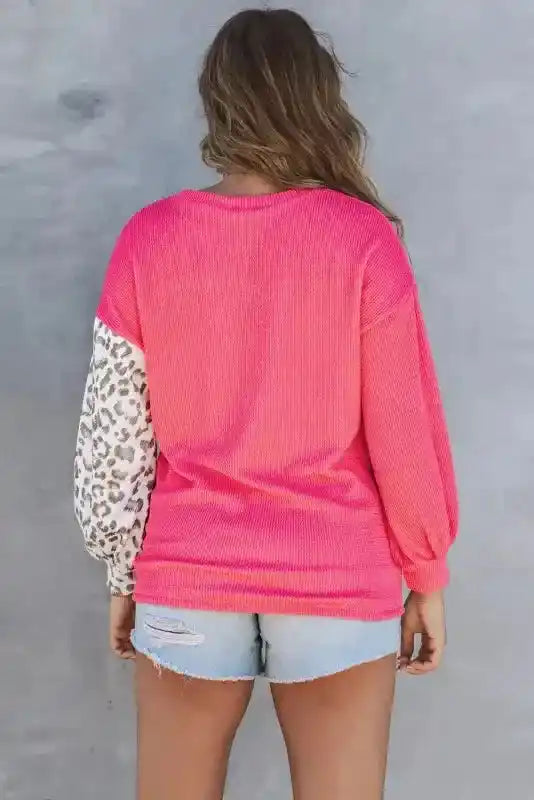 Back view of pink ribbed long sleeve top with leopard print sleeve, showcasing color block design and relaxed fit for fall style.