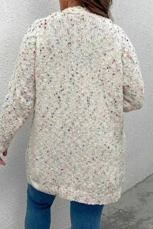 Back view of colorful cable knit sweater cardigan with subtle multicolor dots, offering a relaxed fit for winter layering.