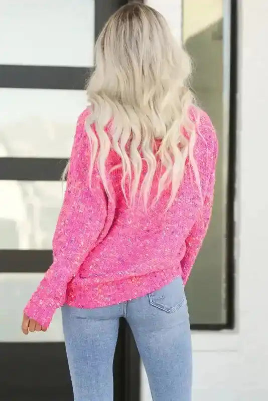 Back view of model in pink colorful cable knit sweater, showcasing relaxed fit and vibrant dotted knit for winter wear.