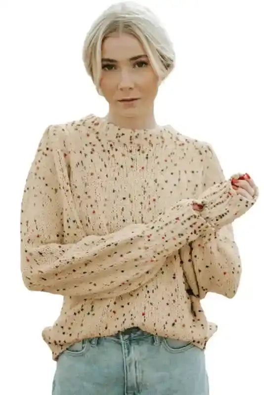 Studio shot of beige colorful cable knit sweater with dotted design and relaxed fit. Great for winter layering and Southern Belle style.