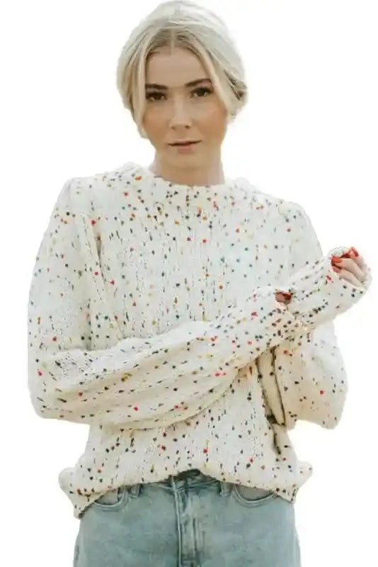 Studio image of white colorful cable knit sweater with vibrant dotted pattern and relaxed fit. Perfect for Southern Belle winter style.