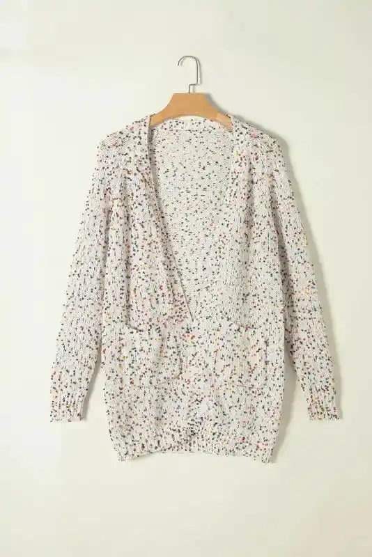 Colorful cable knit sweater cardigan on hanger, featuring vibrant multicolor dots and relaxed fit for cozy winter wear.