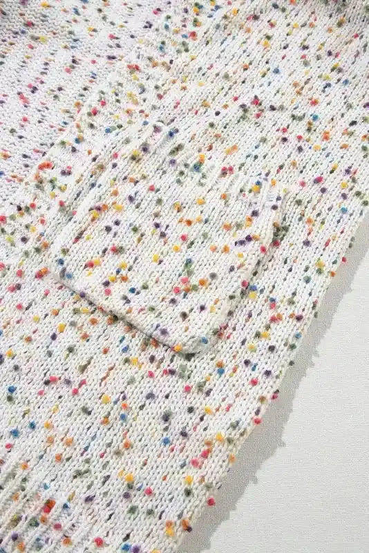 Pocket detail on colorful cable knit sweater with multicolor dots, perfect for stylish and functional winter layering.