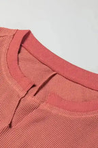 Detail of the slit neckline on dusty rose Women's Exposed Seam Waffle Knit Tunic Top, showing ribbed waffle knit texture.