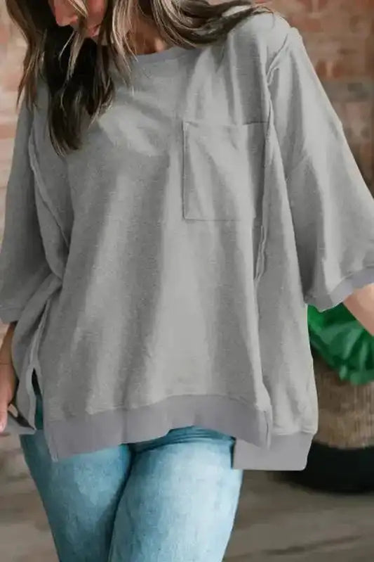Model wearing grey exposed-seam baggy t-shirt with oversized fit and chest pocket