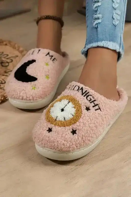 Ladies pink moon and clock pattern fuzzy home slippers with embroidered 'MIDNIGHT' and 'MEET ME' text, styled with ripped jeans.