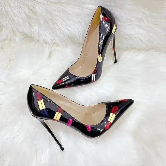 Chic black pumps with colorful lipstick graffiti print, featuring tall stilettos and glossy finish for a fierce fashion-forward look.