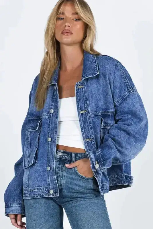Front view of women's casual blue denim jacket with button closure and oversized chest pockets, styled for daily wear.