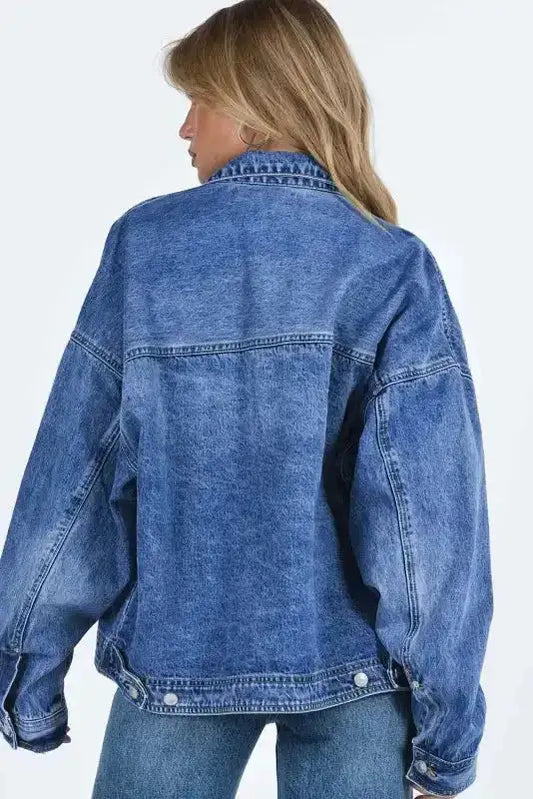 Back view of women's loose denim jacket showing relaxed fit and durable cotton blend fabric, ideal for fall layering.