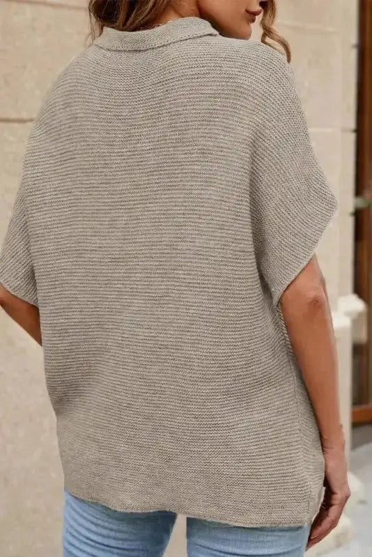 Back view of beige short sleeve sweater showing loose fit and knit texture. Great for autumn daily outfits.