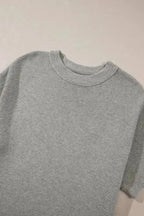 Flat lay of grey high neck short sleeve sweater showing collar and knit texture. Ideal for versatile fall layering.