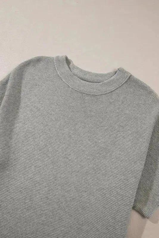 Flat lay of grey high neck short sleeve sweater showing collar and knit texture. Ideal for versatile fall layering.