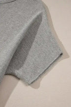 Close-up of short bat sleeve on grey knit sweater highlighting fine texture and soft fabric. Great for daily casual outfits.