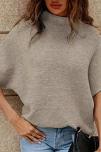 Front view of beige high neck bat sleeve sweater paired with jeans. Cozy and stylish top for fall from FashionFitz.