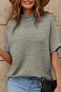 Grey high neck sweater with short bat sleeves styled casually with jeans. Soft knit texture ideal for fall fashion from FashionFitz.