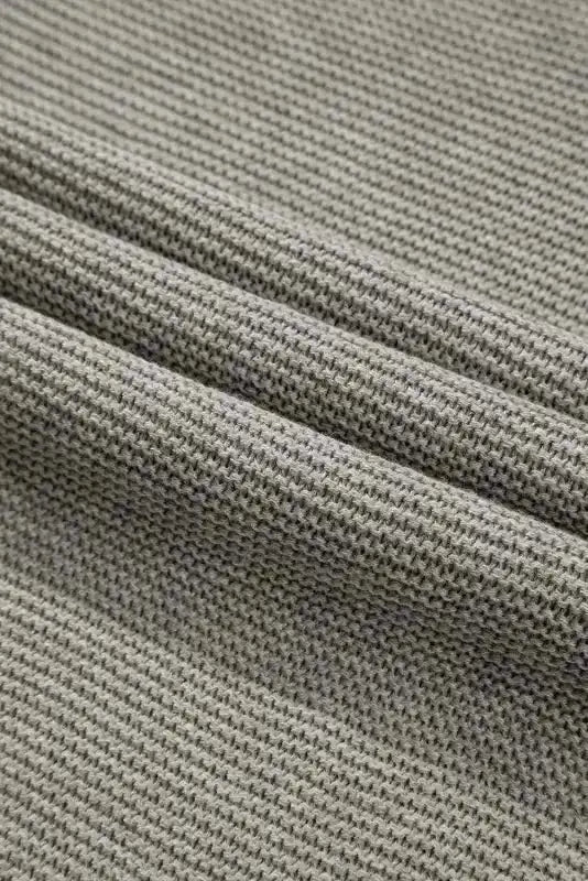 Detailed fabric view of grey high neck sweater showing soft knit weave. Breathable acrylic-cotton blend for fall comfort.