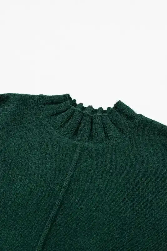Close-up of ribbed mock neckline on dark green batwing knit sweater, showcasing fine knit texture and detail.