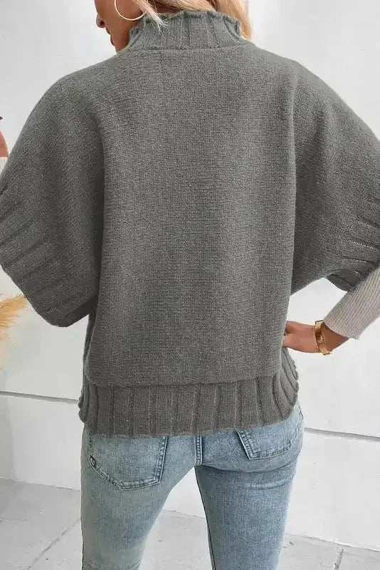Back view of gray short sleeve mock neck batwing knit sweater showing ribbed hem and sleeve detailing.