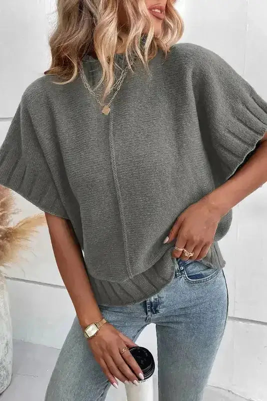 Ladies mock neck batwing knit sweater in gray with short sleeves, styled casually with jeans and layered necklaces.