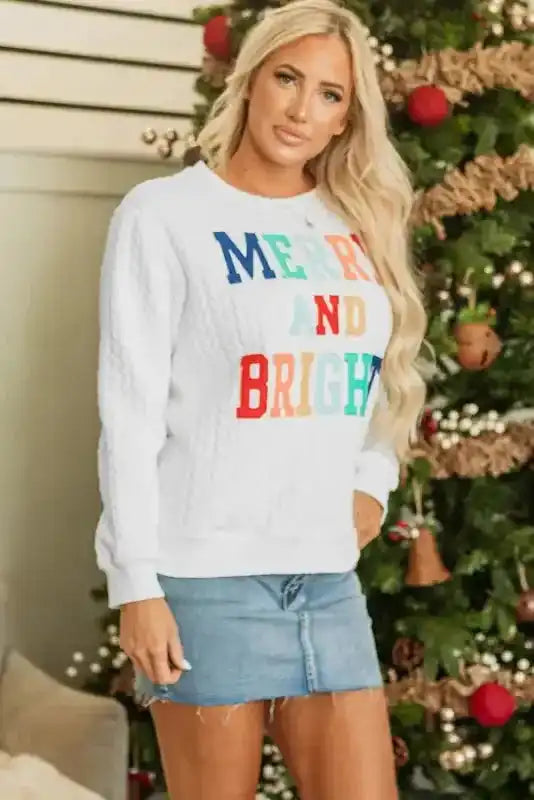 White Merry And Bright Cable Knit Sweatshirt styled for Christmas, paired with a denim skirt for a festive look.