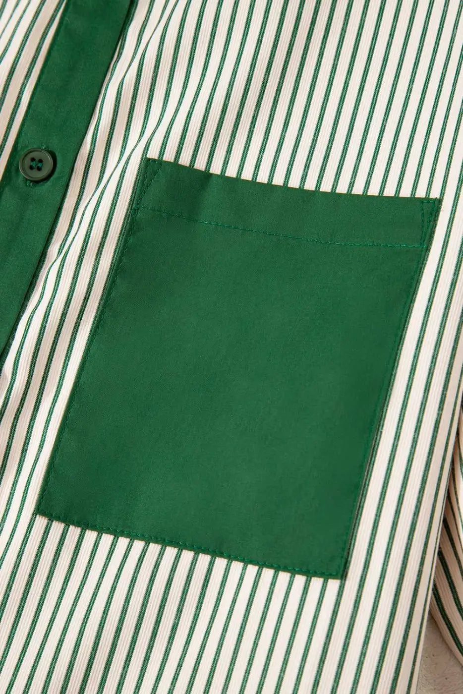 Detail of green pocket on striped mini dress, highlighting the modern monochrome design and casual summer style.