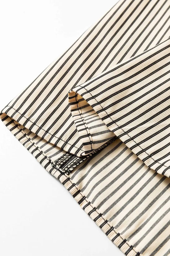 Hem detail of Monochrome Striped Puff Sleeve Mini Dress with clean stitching and vertical monochrome stripes for a feminine summer style.