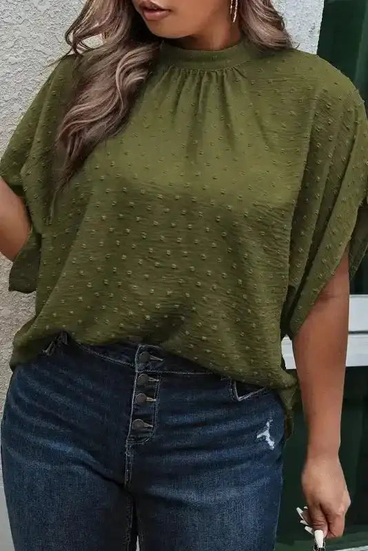 Moss green plus size Swiss dot blouse with mock neck and textured fabric, tucked into button-fly jeans for a chic daytime outfit.