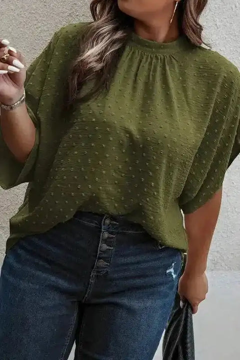 Plus size moss green Swiss dot mock neck blouse with short flutter sleeves, styled with high-waisted jeans for a casual summer look.