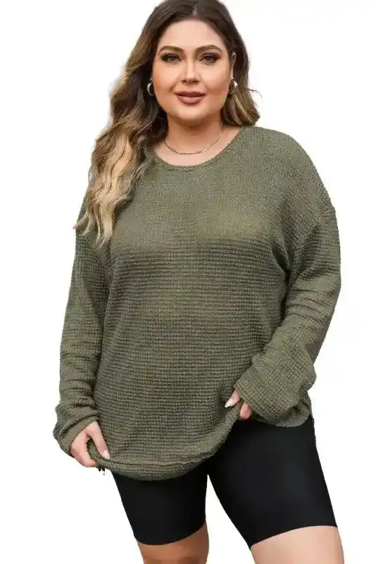 Studio shot of Plus Size model in Moss Green Knit Top with long sleeves and waffle knit texture, styled for autumn comfort.
