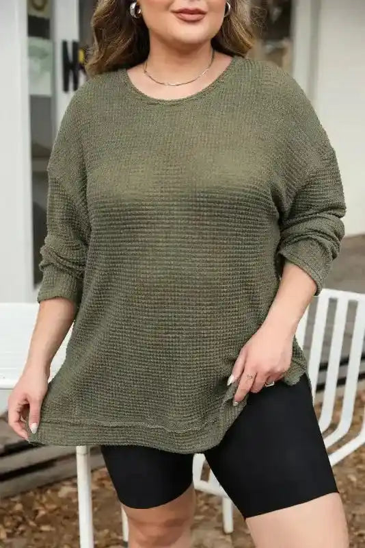 Model in Plus Size Moss Green Knit Top showing front details and casual styling with black shorts for a cozy fall look.