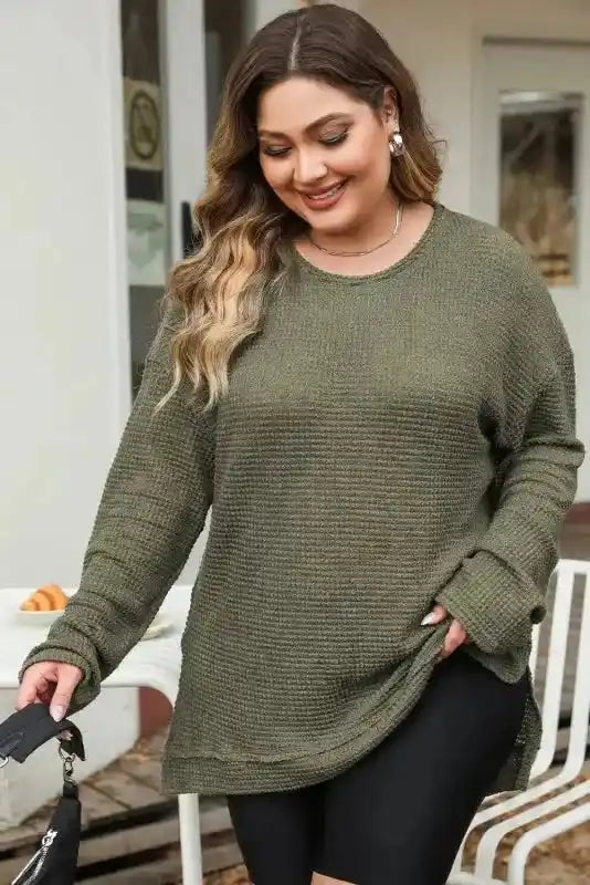 Smiling model in Plus Size Moss Green Knit Top paired with black shorts, perfect for casual autumn days and layering.
