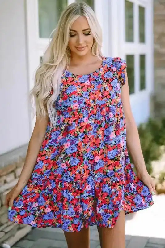 Floral babydoll top for women styled as a mini dress, featuring a flowy tiered design and ruffled sleeves for a breezy summer outfit.