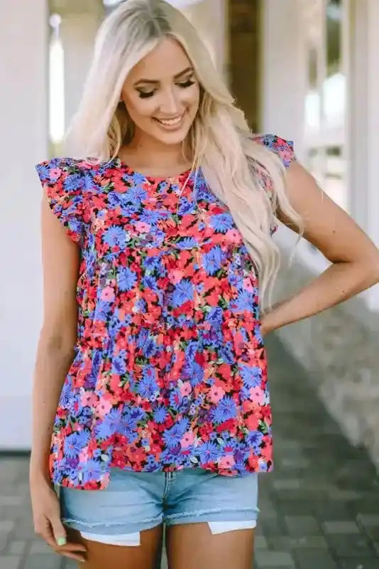 Floral babydoll top for women with flutter sleeves and vibrant floral pattern, styled with denim shorts for a feminine summer look.
