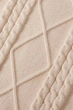 Close-up of oatmeal plus cable knit sweater fabric showing detailed diamond and cable knit texture in soft, cozy yarn.