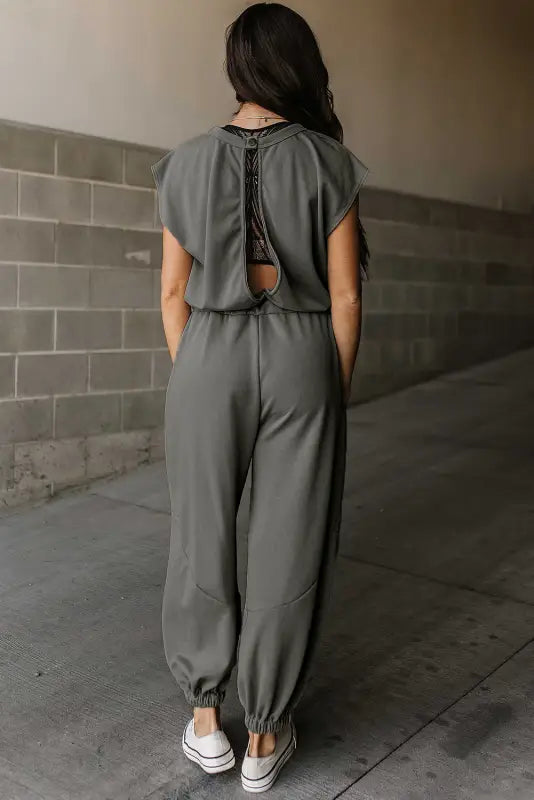 Gray jogger jumpsuit with open back and elastic cuffs for a relaxed, stylish look