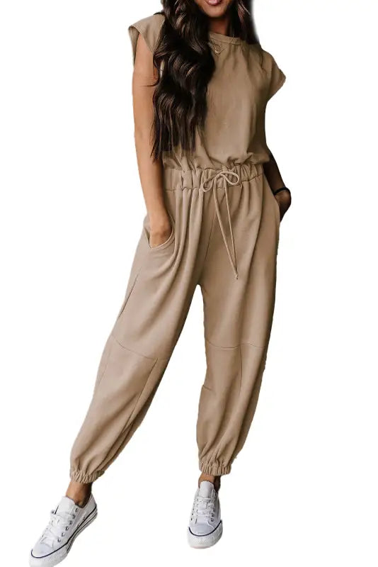 Open back drawstring jogger jumpsuit: beige jumpsuit with white sneakers, relax relax style