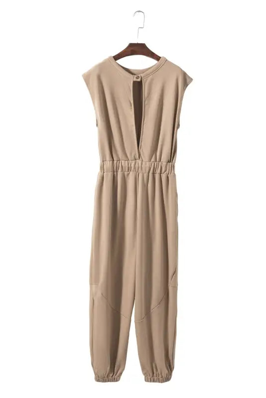 Open back drawstring jogger jumpsuit: beige sleeveless jumpsuit with a plunging neckline