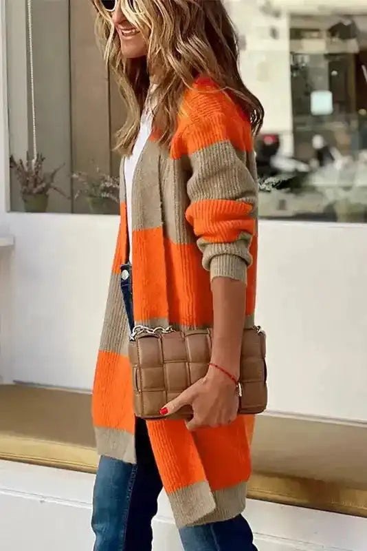 Side profile of orange and beige ribbed knit cardigan, styled with jeans and quilted handbag for a cozy fall look.