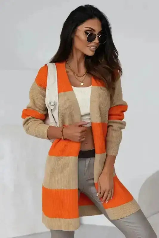 Chic orange cardigan with colorblock ribbed knit in beige and orange, styled with crop top and gray pants for a modern fall look.