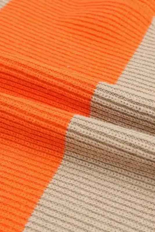 Close-up of ribbed knit fabric in orange and beige colorblock, highlighting the soft texture and quality of the cardigan material.